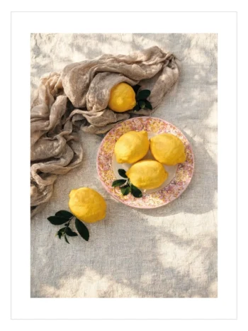 Pembe çiçek desenli tabakta sarı limonların yer aldığı natürmort poster